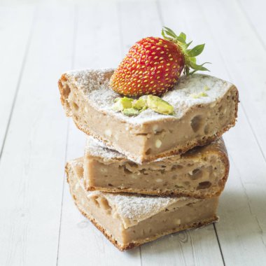 Çilek ile süzme peynir güveç kısmında ve nane, Antep fıstığı hafif bir arka plan üzerinde. Kahvaltı kavramı.