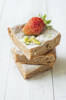 Çilek ile süzme peynir güveç kısmında ve nane, Antep fıstığı hafif bir arka plan üzerinde. Kahvaltı kavramı.