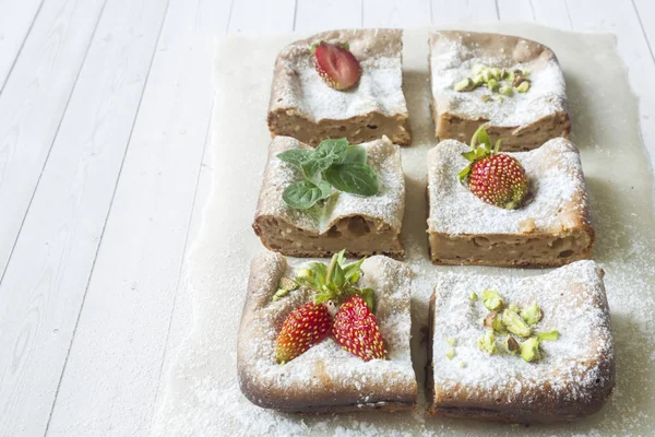 Çilek ile süzme peynir güveç kısmında ve nane, Antep fıstığı hafif bir arka plan üzerinde. Kahvaltı kavramı.