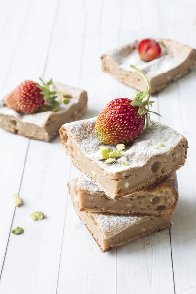 Çilek ile süzme peynir güveç kısmında ve nane, Antep fıstığı hafif bir arka plan üzerinde. Kahvaltı kavramı.