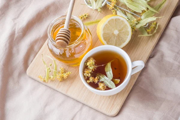 Tea with Linden, honey and Lemon. The tray on the bed, the Concept of the treatment of colds.