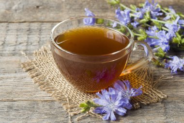 Hindiba iç Kupası ve çiçekler rustik ahşap zemin üzerinde. Tıbbi bitki Cichorii