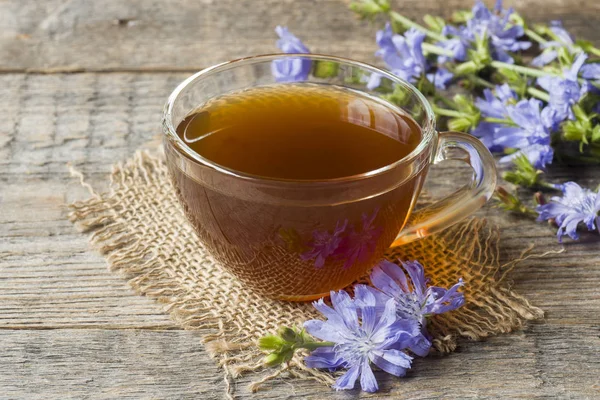 Hindiba iç Kupası ve çiçekler rustik ahşap zemin üzerinde. Tıbbi bitki Cichorii