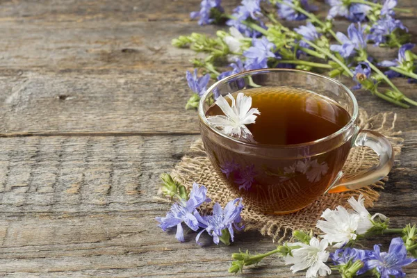 Hindiba iç Kupası ve çiçekler rustik ahşap zemin üzerinde. Tıbbi bitki Cichorii