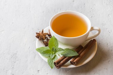 Çay taze nane yaprakları ve gri beton zemin üzerine tarçın Yıldız anason ile.