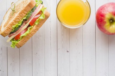 Aperatif için okul sandviç, taze elma ve portakal suyu. Renkli okul malzemeleri. Kopya alanı