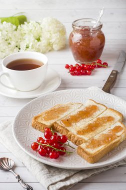 Sağlıklı kahvaltı kahve beyaz masanın üzerine kızarmış ekmek, reçel ve kırmızı kuş üzümü,