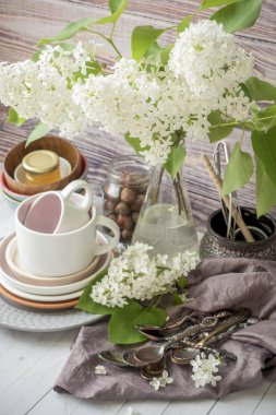 Birçok farklı sofra boş. Beyaz Leylak buket. Ahşap arka plan koyu peçete.