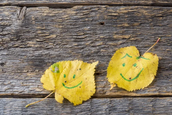 Gelbe Herbstblätter Mit Smiley Mustern Auf Holzgrund — Stockfoto