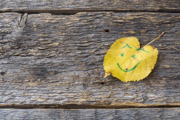 Gelbe Herbstblätter Mit Smiley Mustern Auf Holzgrund — Stockfoto