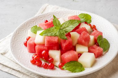 Bir tabağa karpuz, kavun, frenk üzümü ve nane taze sulu adet salata yaprakları