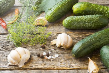 Salatalık turşusu, sarımsak ve baharat için ahşap bir masa üzerinde bir kavanoza dekapaj
