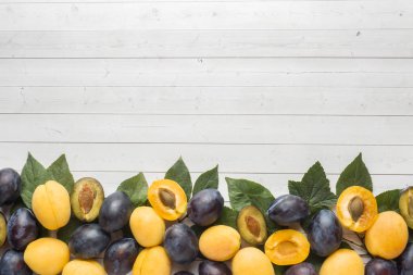 Taze erik ve kayısı çilek ile masa lambası yapraklarda