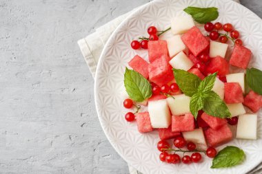 Bir tabağa karpuz, kavun, frenk üzümü ve nane taze sulu adet salata yaprakları