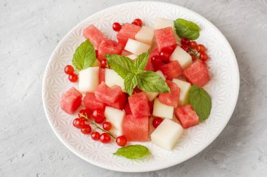 Bir tabağa karpuz, kavun, frenk üzümü ve nane taze sulu adet salata yaprakları