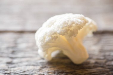 Karnabahar taze organik, ahşap arka plan üzerinde küçük parçalar halinde kesilmiş.