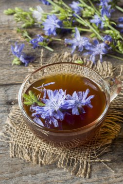 Hindiba iç Kupası ve çiçekler rustik ahşap zemin üzerinde. Tıbbi bitki Cichorii