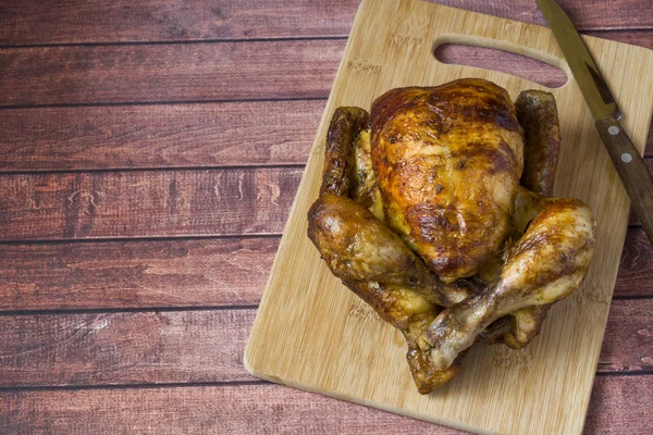 Ahşap arka plan üzerinde ağır kavrulmuş ızgara tavuk.