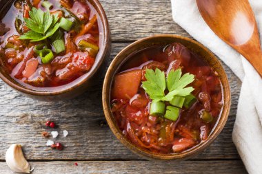 Borsch, Pancar çorbası ahşap arka plan üzerinde taze otlar bir ahşap kase.