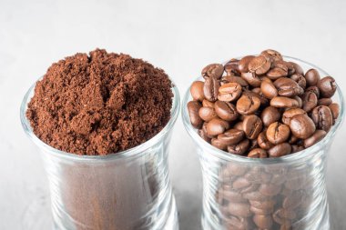 İki cam bardak kahve çekirdekleri ve hafif beton zemin üzerine çekilmiş kahve ile.