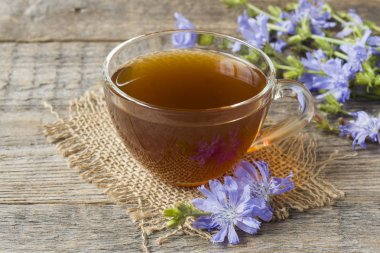 Hindiba iç Kupası ve çiçekler rustik ahşap zemin üzerinde. Tıbbi bitki Cichorii