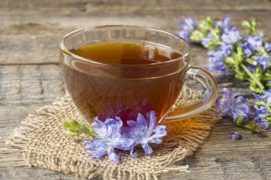 Hindiba iç Kupası ve çiçekler rustik ahşap zemin üzerinde. Tıbbi bitki Cichorii