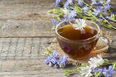 Hindiba iç Kupası ve çiçekler rustik ahşap zemin üzerinde. Tıbbi bitki Cichorii