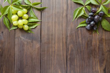 kopya alanı ile ahşap masa arka plan üzerinde kırmızı ve beyaz üzüm demet.