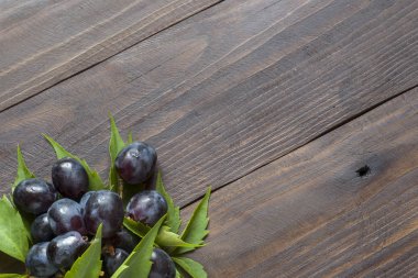 Ahşap bir masa arka plan boşluk bir kopyasıyla üzerinde kırmızı üzüm demet.