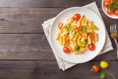 Makarna, domates soslu makarna ve peynir ahşap bir masa üzerinde bir tabak içinde.