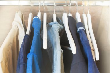 Mavi ve gri t-shirt askıları dolabın üzerinde. Görüntü. Seçici odak