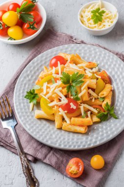 Makarna, domates soslu makarna ve peynir ahşap bir masa üzerinde bir tabak içinde.