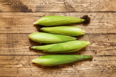 Kırsal ahşap masadaki koçanlarda taze mısır, yakın plan..