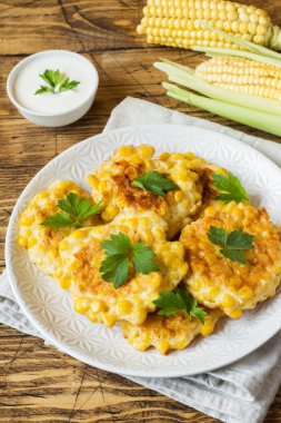 Maydanoz bir plaka üzerinde konserve mısır taneleri dan beşamel sos. Ahşap arka plan