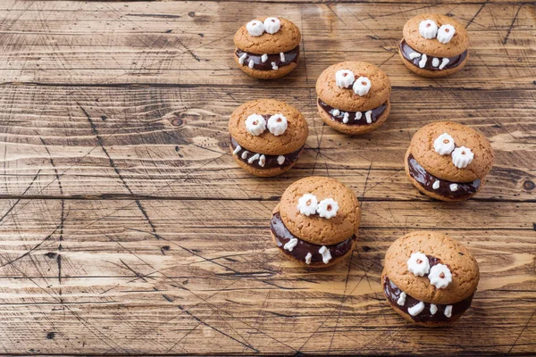 Cookies with chocolate paste in the form of monsters for Halloween.