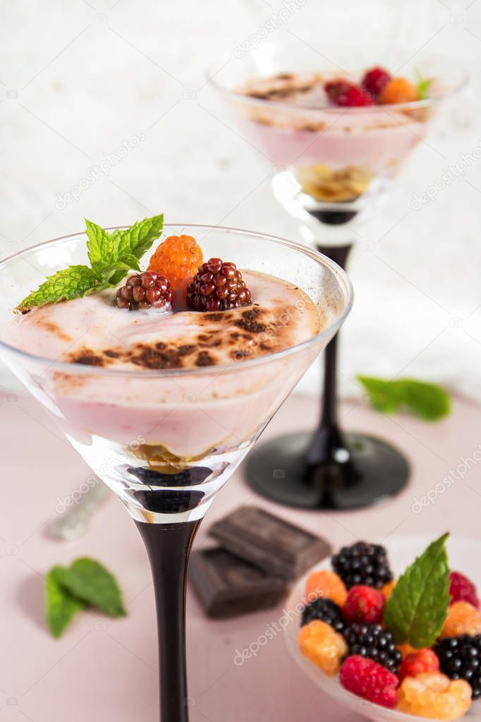 Milk dessert with berries in tall glasses. Selective focus