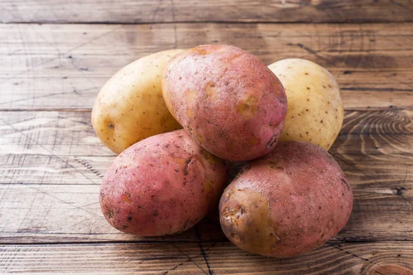 Raw potato red and yellow food. Fresh potatoes on wooden background