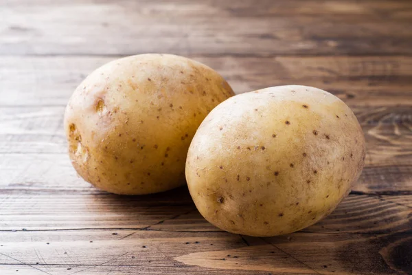 Raw potato yellow food. Fresh potatoes on wooden background