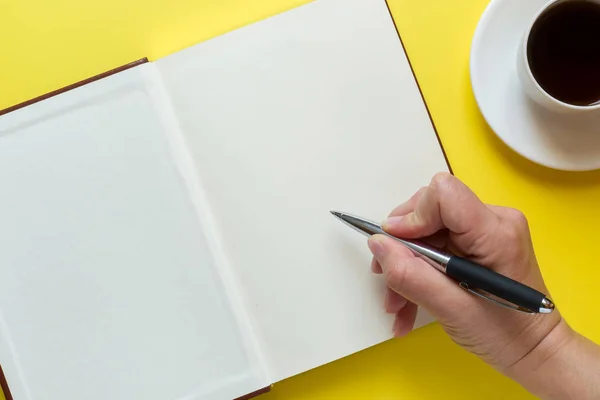 コピー スペースとコーヒーの黄色い机のカップ 手書き込みペン日記を開設教育と事務所のコンセプト — ストック写真