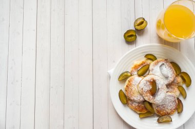 Peynirli Krep içinde bir plaka üzerinde taze erik ile pudra şekeri. Kopya alanı.