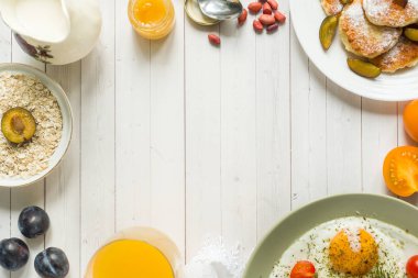 Kahvaltı kavramı. Kızarmış yumurta, peynir krep, Erik ve yulaf ezmesi masanın üzerine süt, portakal suyu.