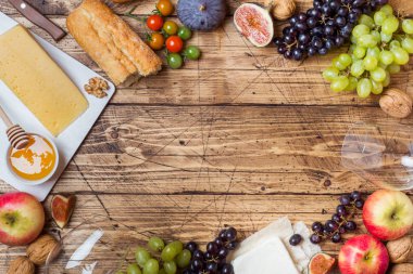 Peynir, şarap, baget üzüm incir bal ve rustik ahşap masa üstü kopya alanı ile snacks