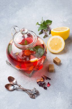 Cam demlik çay, nane ve limon ile kopya alanı gri tabloda.