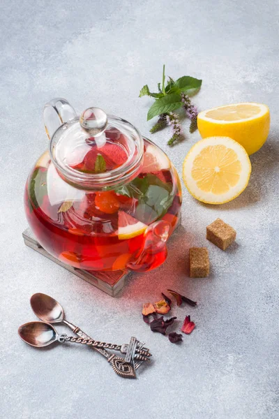 Cam demlik çay, nane ve limon ile kopya alanı gri tabloda.