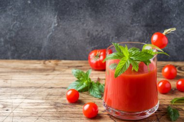 Domates suyu ile nane cam ve ahşap bir masa üzerinde taze domates. Sağlıklı organik gıda kavramı. Kopya alanı