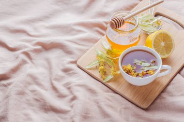 Linden, bal ve limon ile çay. Yatak, soğuk algınlığı tedavisinde kavramı tepsiye