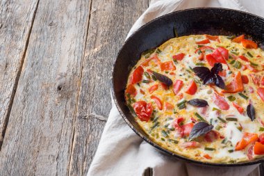 Pan yakın çekim sebzeli omlet. Ahşap arka plan, üstten görünüm yatay.