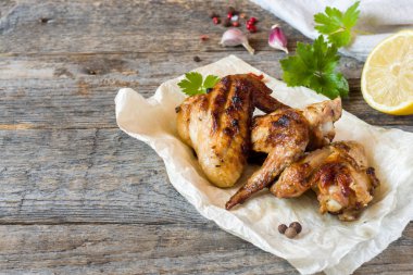 Tavuk kanadı pişmiş ızgara ile taze otlar, limon ahşap arka plan üzerinde