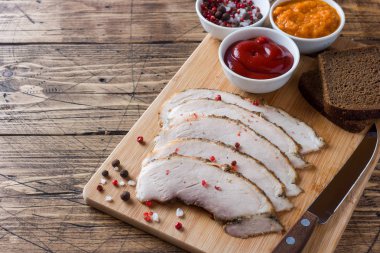 Ekmek, soslar ve baharat ahşap bir masa üzerinde bir ahşap rustik tahtada füme haşlanmış domuz eti parçaları. Kopya alanı.