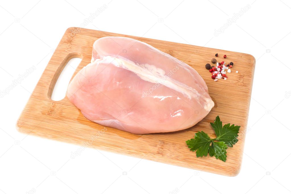 Raw chicken Breasts and spices on wood chopping Board isolated on white.